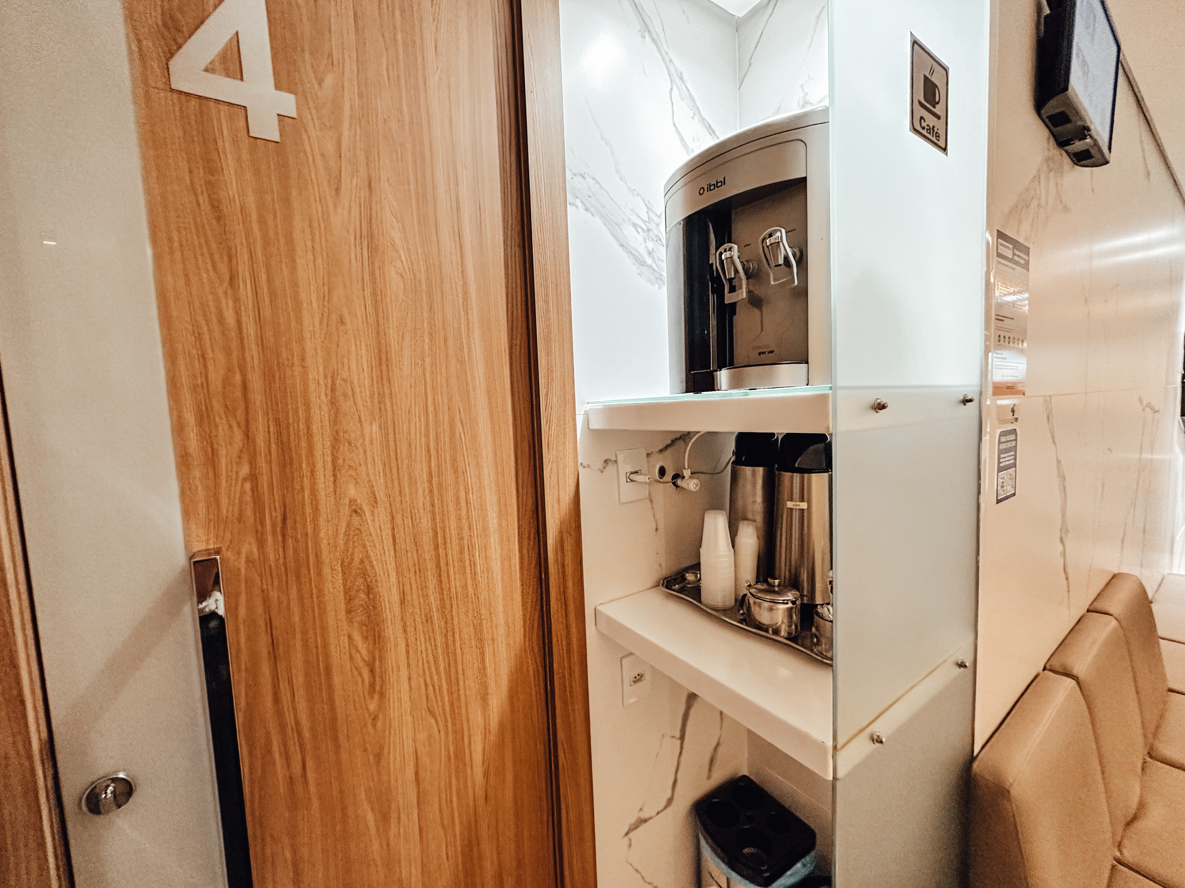 Detalhe da área de espera com assentos e espaço para café
